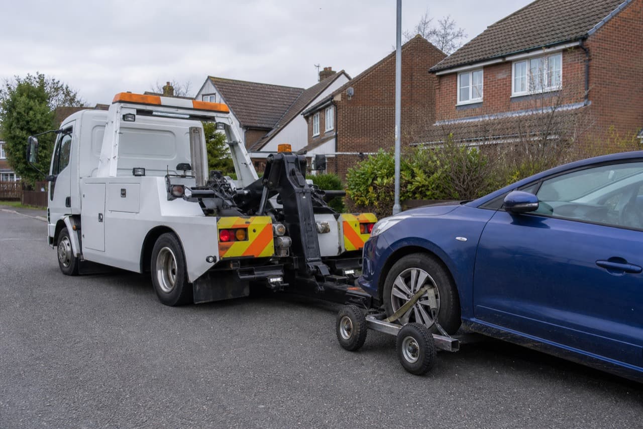 Recovery truck using a wheel-lift and dollies under a car